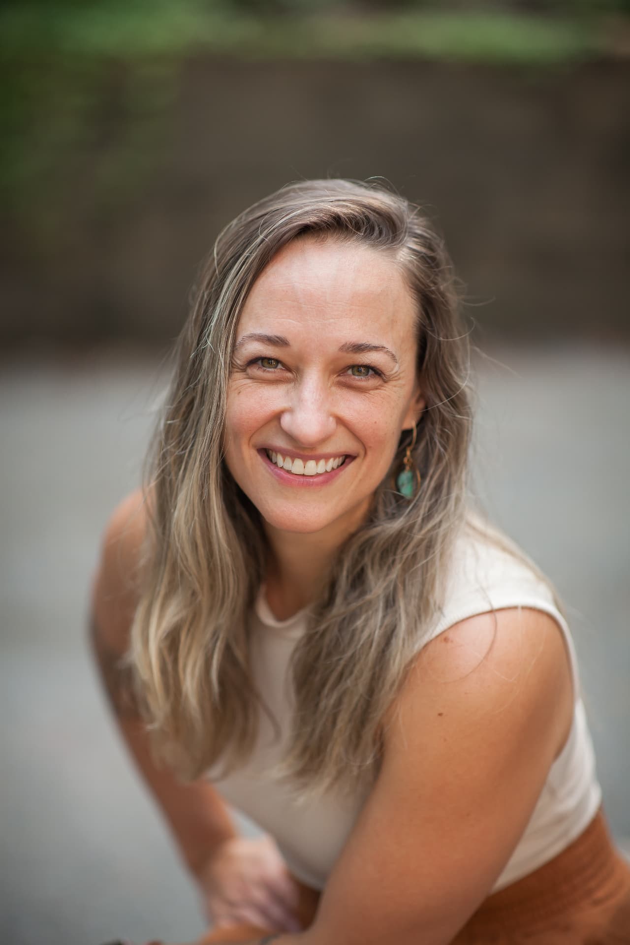 Jules Sawyer, Asheville luxury cohost and hospitality manager, smiling by the river